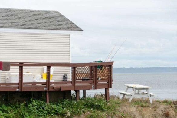 Une maison en bois avec une terrasse offrant une vue imprenable, idéale comme logement proche de la plage.