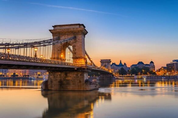 Pont des Chaînes illuminé au crépuscule au-dessus du Danube pour illustrer les monuments de Budapest.